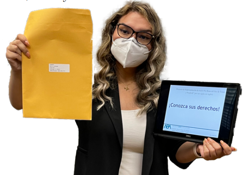 Photo of woman holding manila envelope and computer tablet.