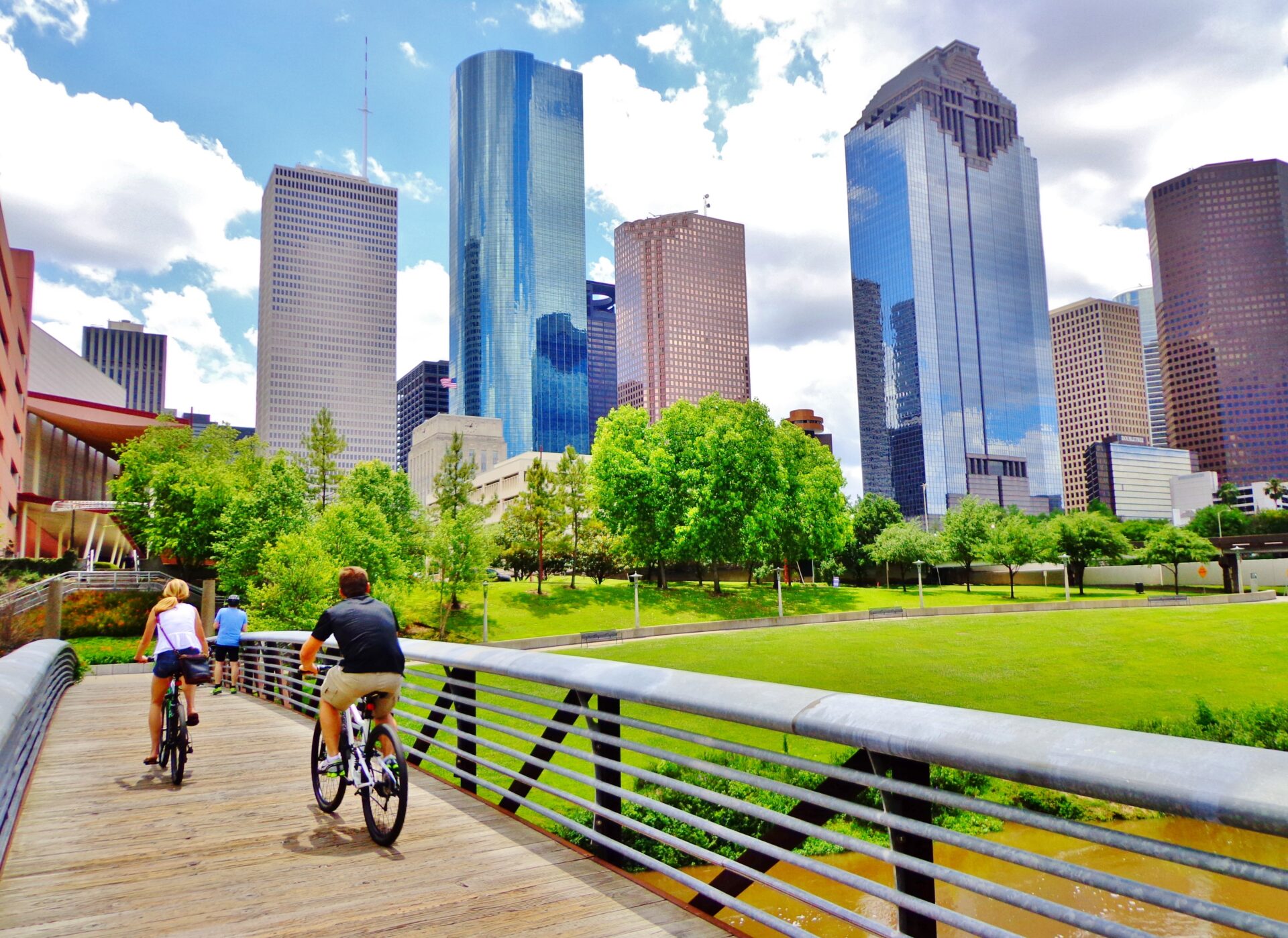 Bicyclists cross wooden bridge in Buffalo Bayou Park - Houston, Texas, USA